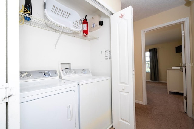 laundry area with carpet floors, washing machine and dryer, and a textured ceiling