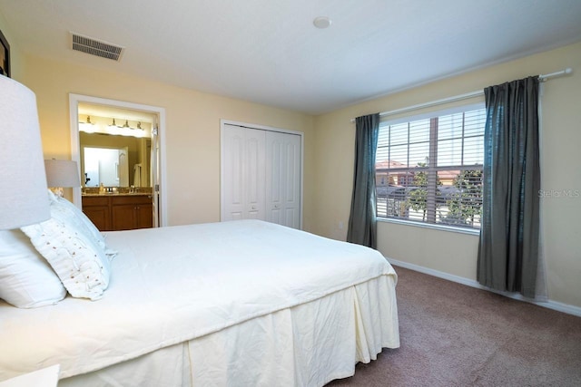 carpeted bedroom featuring a closet and ensuite bath