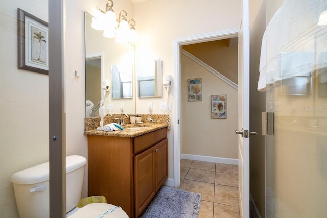 bathroom with toilet, vanity, and tile patterned floors