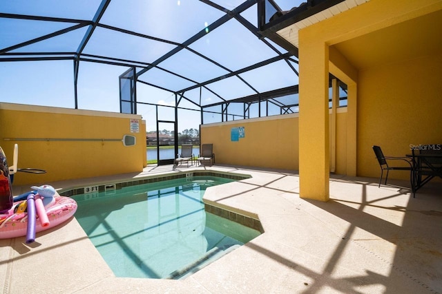 view of swimming pool with glass enclosure and a patio area