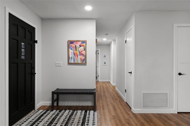 entryway with wood-type flooring and a textured ceiling