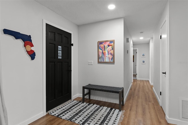 entrance foyer with a textured ceiling and hardwood / wood-style flooring