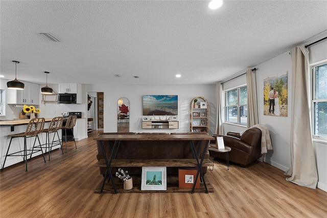 living room featuring a textured ceiling and light hardwood / wood-style floors