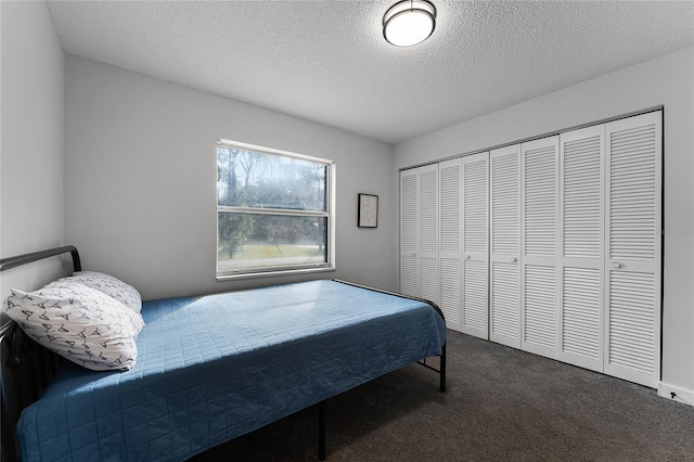 carpeted bedroom featuring a textured ceiling and a closet