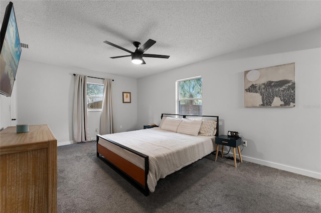 bedroom with ceiling fan, a textured ceiling, and dark colored carpet