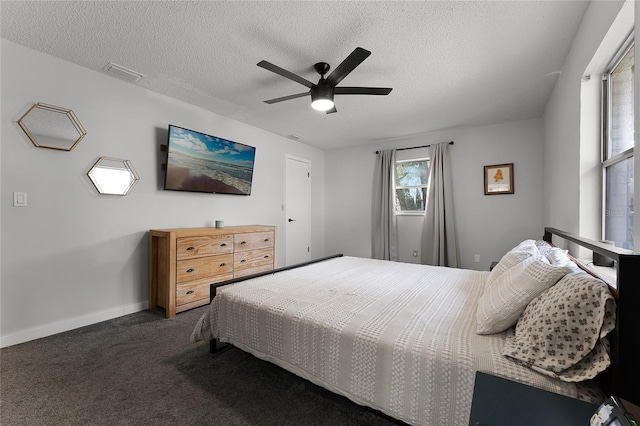 carpeted bedroom with ceiling fan and a textured ceiling