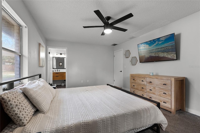 carpeted bedroom with a textured ceiling, ceiling fan, and ensuite bathroom