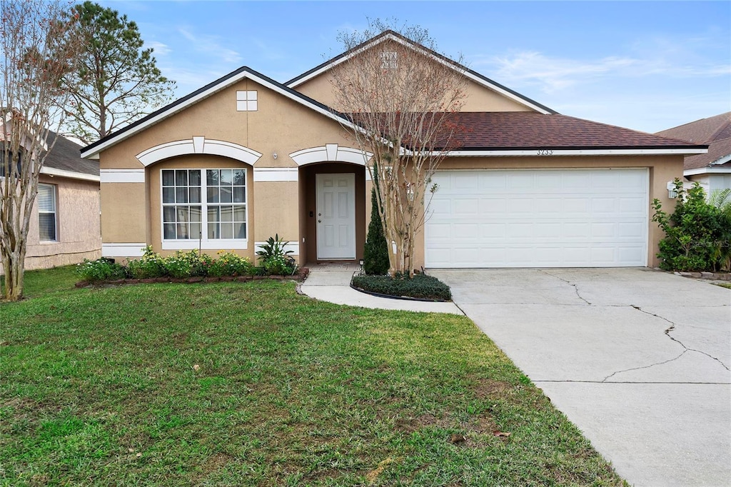 single story home featuring a garage and a front lawn