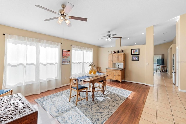 dining space with ceiling fan and light wood-type flooring