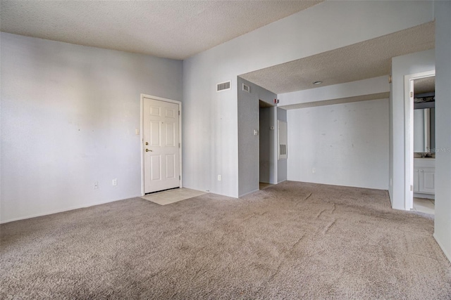 carpeted empty room with a textured ceiling