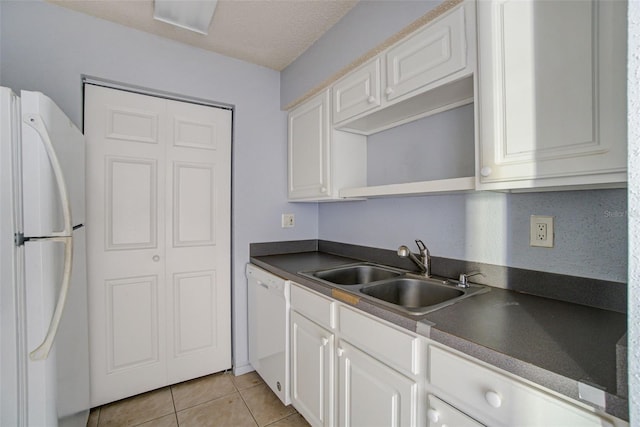 kitchen with sink, white cabinetry, light tile patterned flooring, white appliances, and a textured ceiling