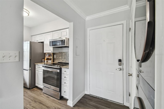 kitchen with white cabinetry, stainless steel appliances, dark hardwood / wood-style floors, backsplash, and light stone counters