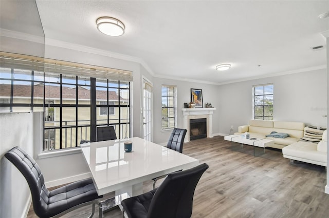 dining space featuring hardwood / wood-style floors and ornamental molding