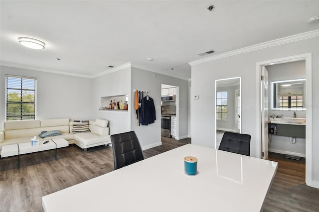 dining area featuring dark wood-type flooring and ornamental molding