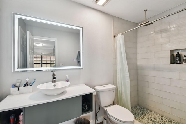 bathroom with toilet, a shower with shower curtain, and vanity