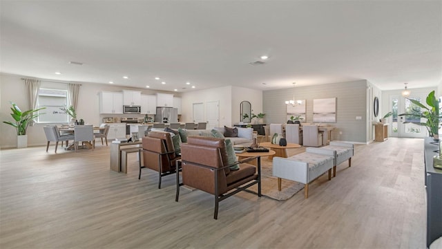 living room with light hardwood / wood-style flooring and a notable chandelier