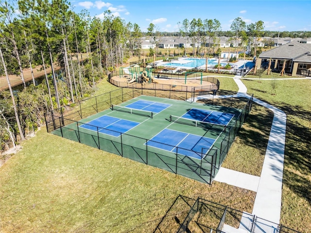 view of sport court with a playground and a lawn