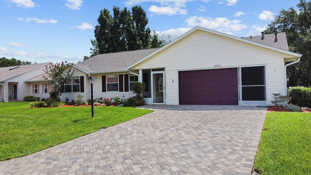 ranch-style house featuring a garage and a front lawn