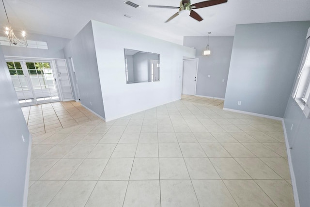 unfurnished room with ceiling fan with notable chandelier and light tile patterned flooring