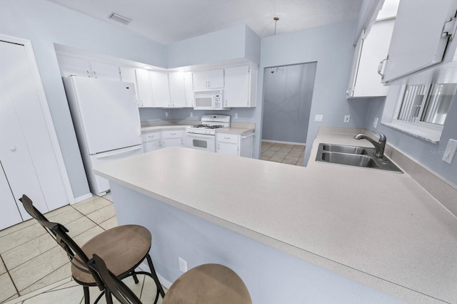 kitchen featuring sink, white cabinets, a kitchen breakfast bar, kitchen peninsula, and white appliances