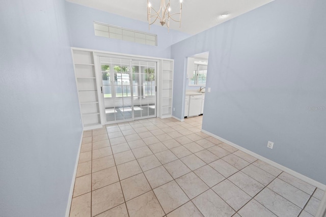 tiled empty room with an inviting chandelier