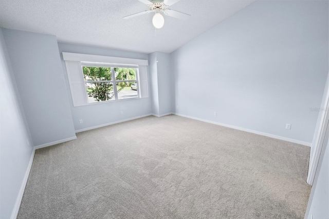 spare room with ceiling fan, light colored carpet, and a textured ceiling