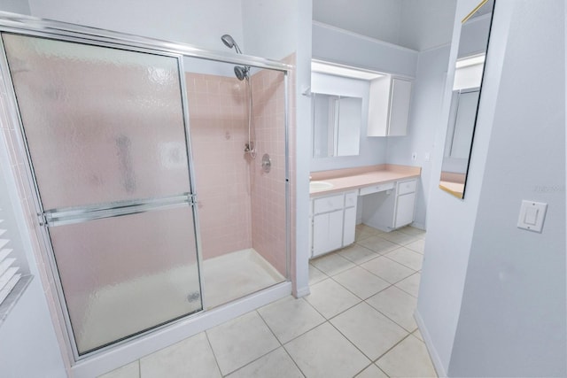 bathroom featuring tile patterned floors, vanity, and a shower with shower door