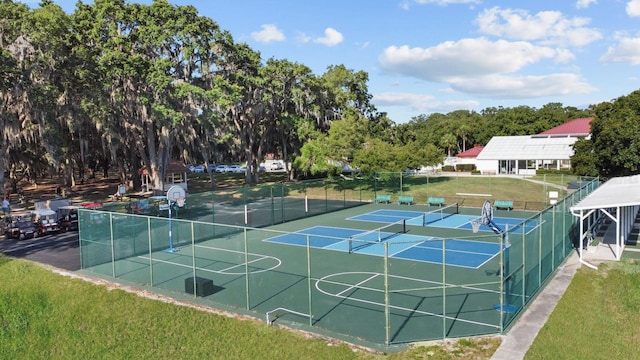 view of property's community with tennis court, a yard, and basketball hoop