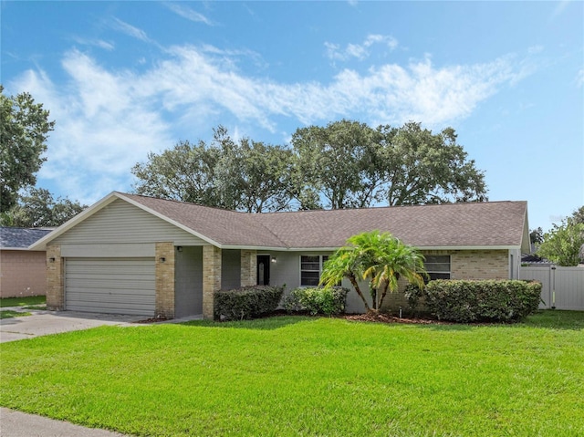 ranch-style home featuring a front yard, concrete driveway, brick siding, and an attached garage