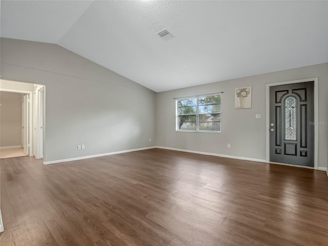 unfurnished living room with vaulted ceiling, dark hardwood / wood-style flooring, and a textured ceiling