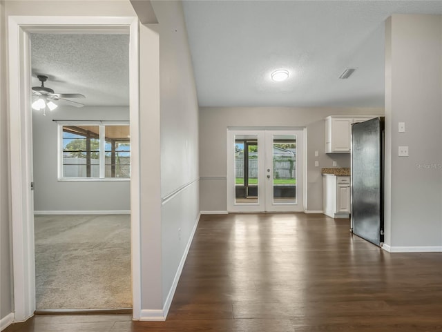 interior space featuring ceiling fan, dark carpet, a textured ceiling, and french doors