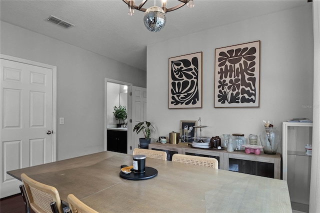 dining area with a textured ceiling and a chandelier