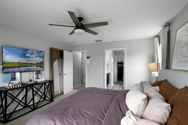 carpeted bedroom featuring ceiling fan, a textured ceiling, and ensuite bathroom