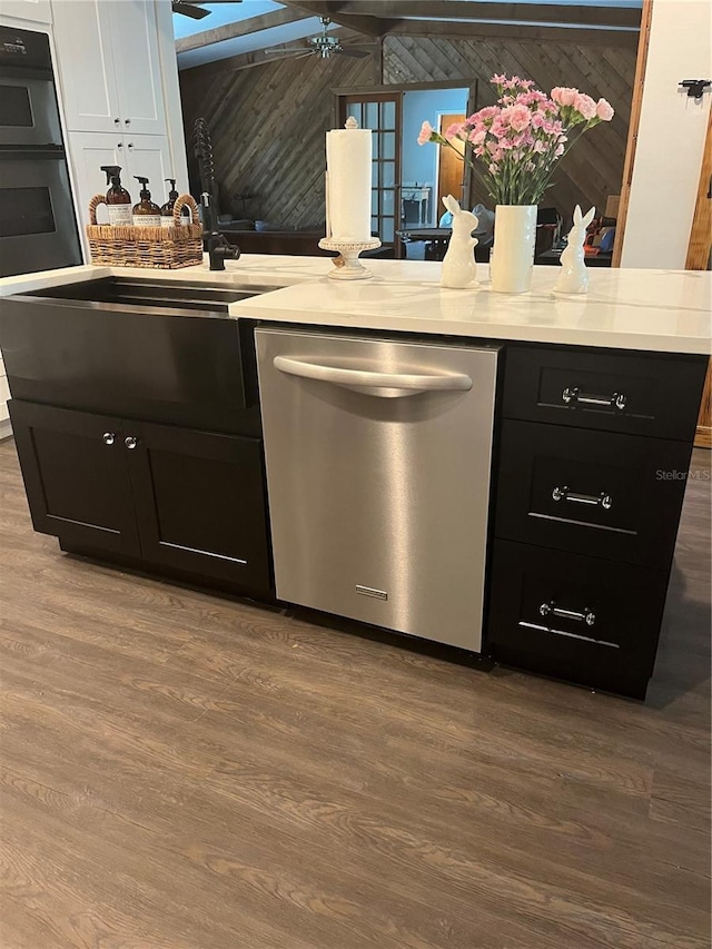 kitchen with multiple ovens, stainless steel dishwasher, sink, and light hardwood / wood-style floors