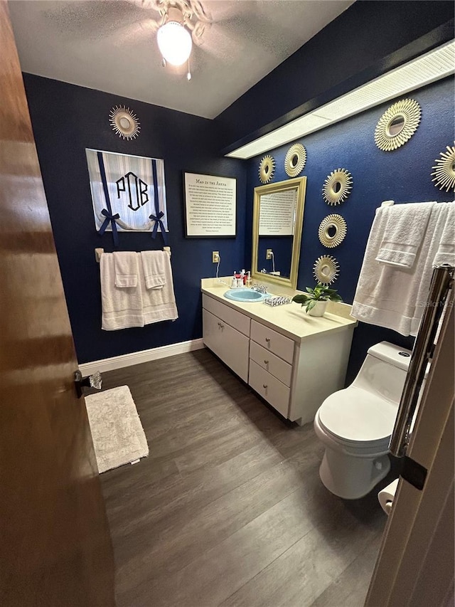 bathroom featuring vanity, hardwood / wood-style floors, toilet, and a textured ceiling