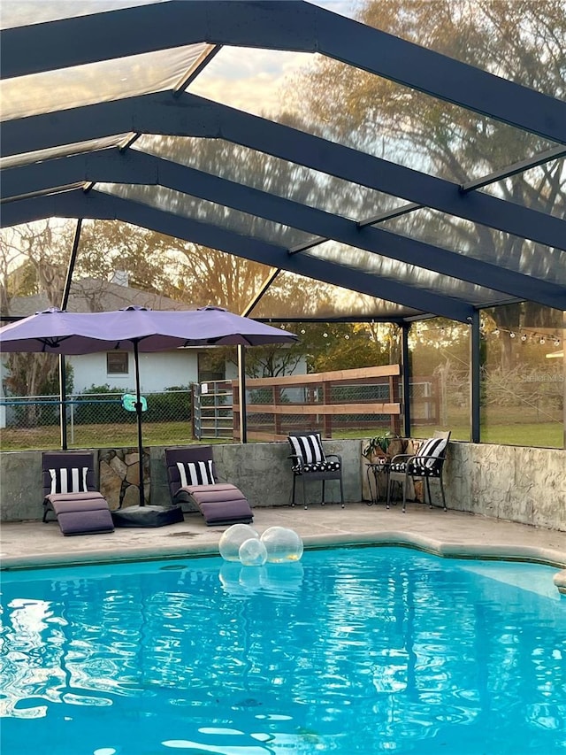 view of pool featuring glass enclosure