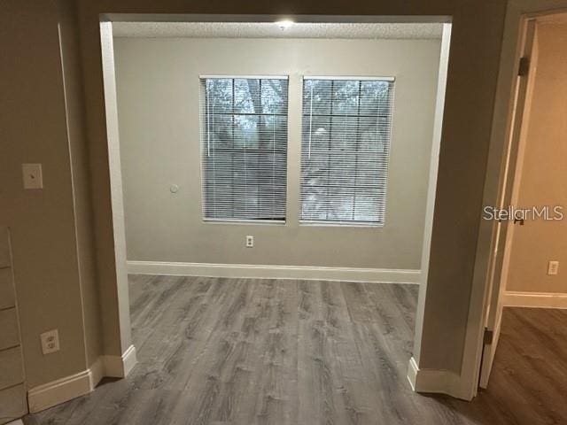 empty room with wood-type flooring and a textured ceiling