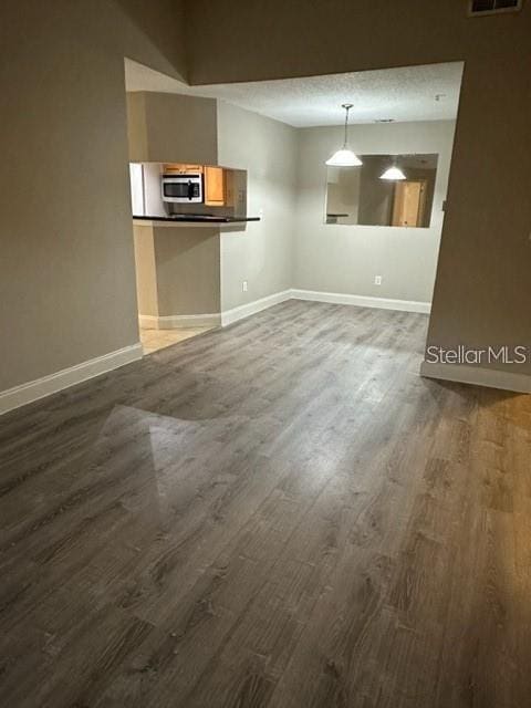 unfurnished dining area with dark wood-type flooring