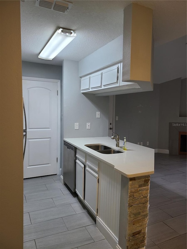 kitchen with sink, dishwasher, white cabinetry, and kitchen peninsula