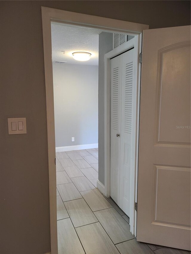 hall with a textured ceiling