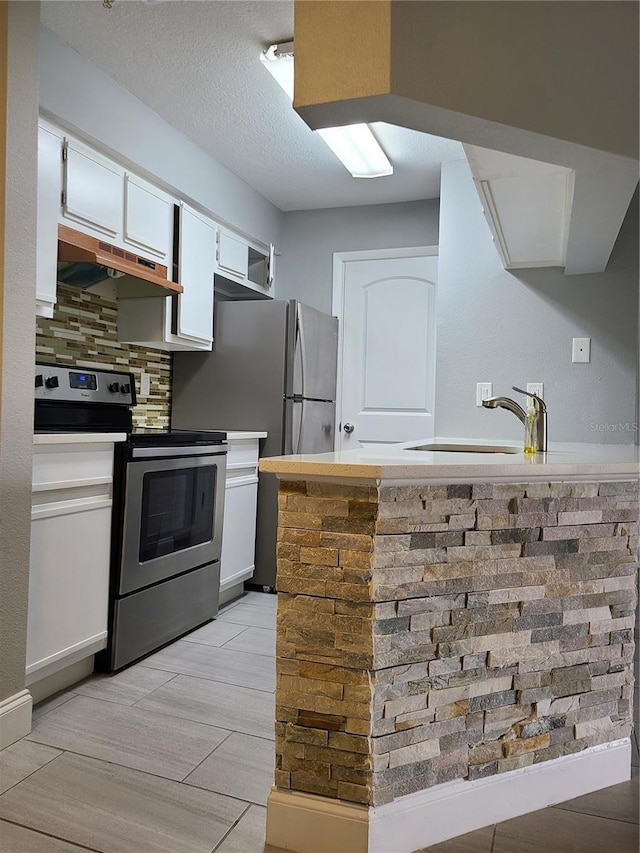 kitchen with a textured ceiling, white cabinetry, decorative backsplash, sink, and stainless steel electric range