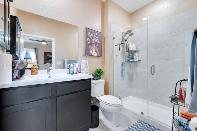 bathroom with a shower with shower door, toilet, vanity, and tile patterned flooring