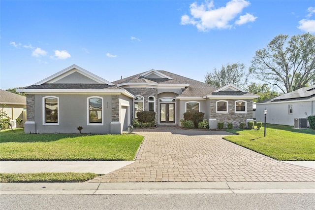 single story home with central AC unit, a garage, and a front lawn