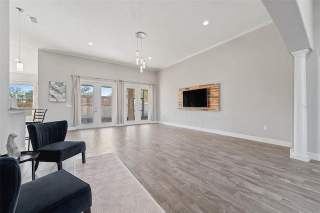 living room with light hardwood / wood-style floors, crown molding, decorative columns, and french doors