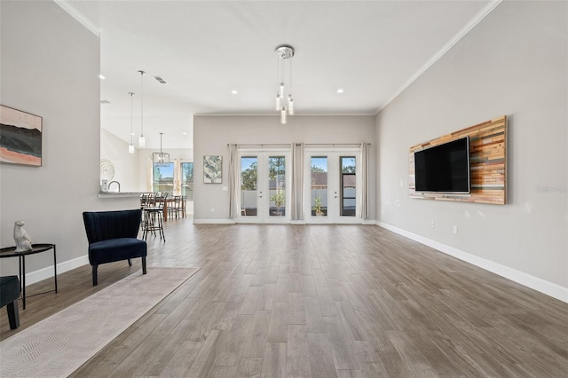 unfurnished living room with french doors, ornamental molding, and hardwood / wood-style floors