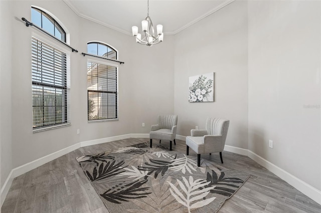 living area featuring ornamental molding, light hardwood / wood-style floors, and a notable chandelier