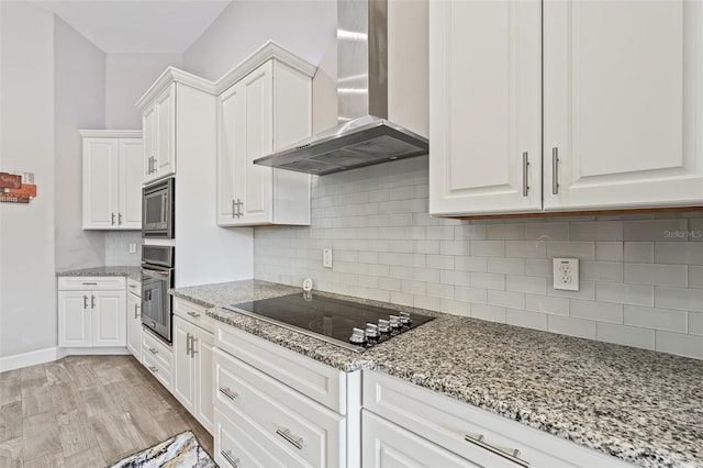 kitchen with white cabinetry, appliances with stainless steel finishes, light hardwood / wood-style flooring, and wall chimney range hood