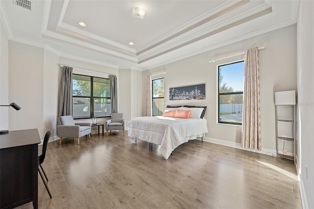 bedroom featuring crown molding, a tray ceiling, and hardwood / wood-style flooring