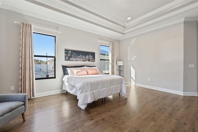 bedroom with a tray ceiling, crown molding, and dark hardwood / wood-style floors