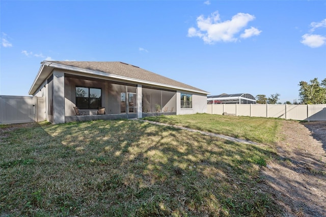 rear view of property with a sunroom and a yard